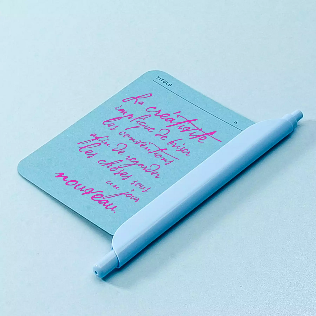citation creativite sur un foglietto bleu vierge et un stylo bille clipen bleu